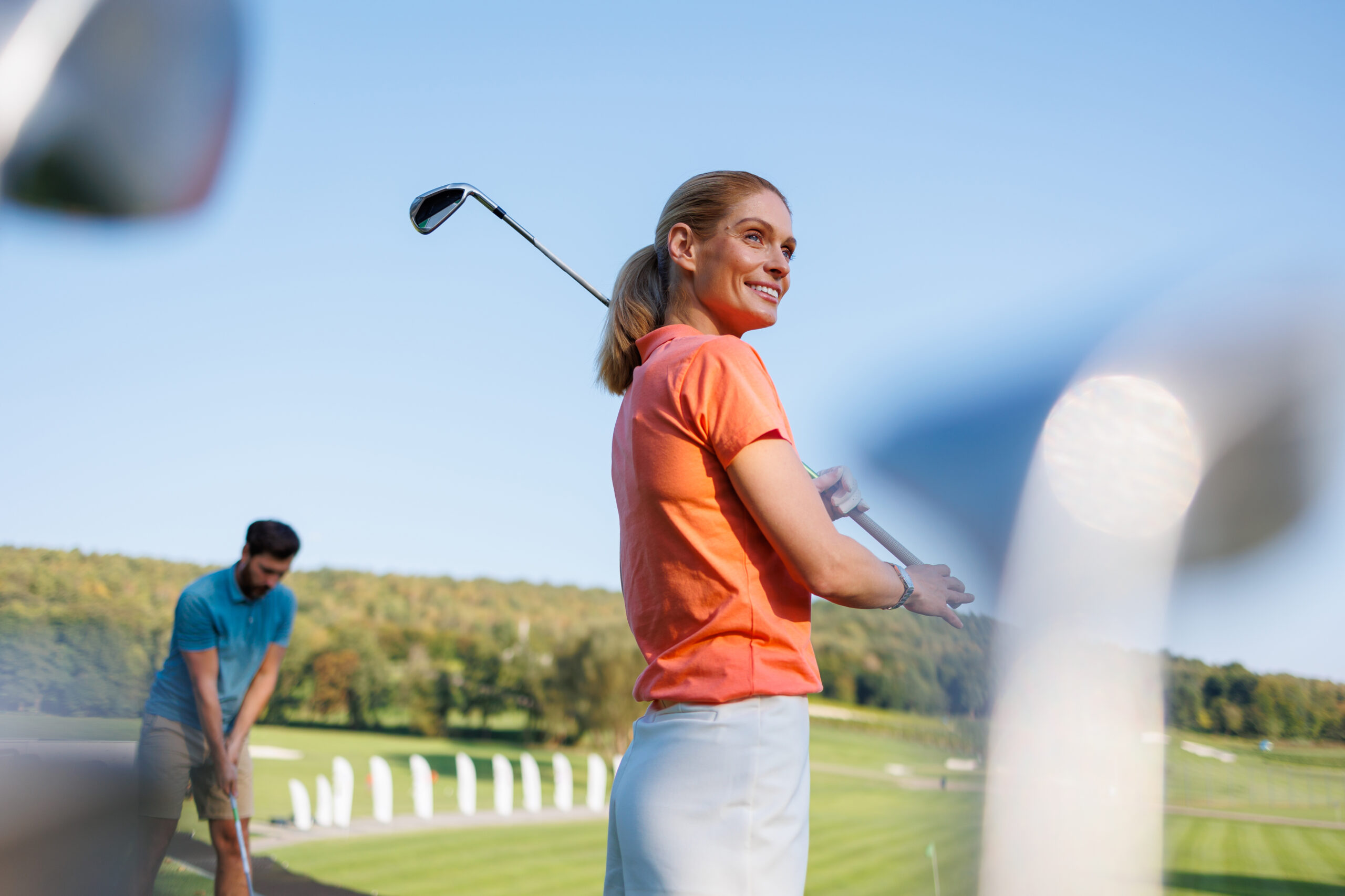 Champ de pratique - Femme avec son baton de golf sur un champ de pratique